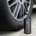 車のタイヤにMOJIETU空気入れで空気を入れている写真